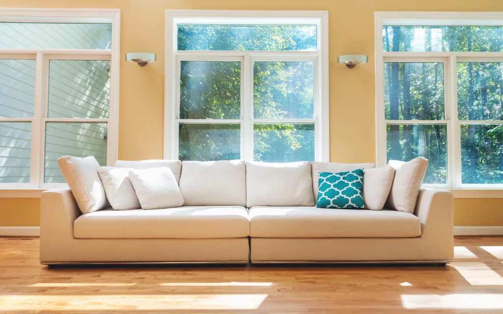 Bright living room interior showcasing a large wall of newly replaced double-hung windows in Toledo, Ohio.