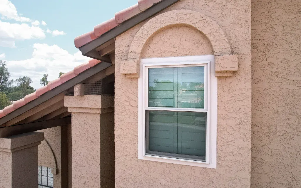 White replacement window on a stucco home exterior