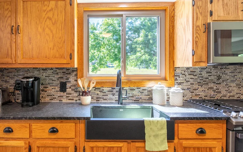 White sliding replacement window above a kitchen sink
