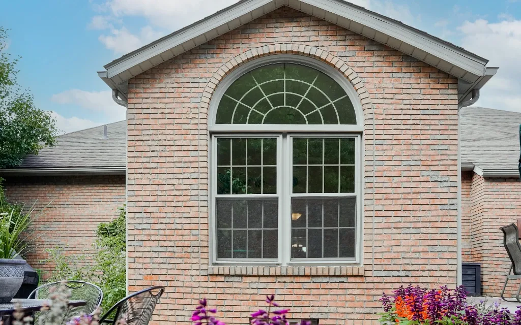 Custom arched replacement window on a brick home